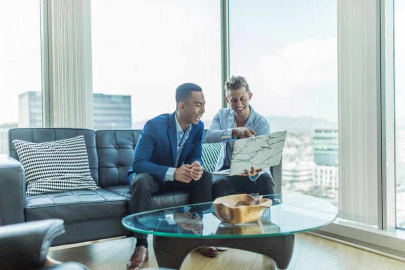 two young businessmen using laptop