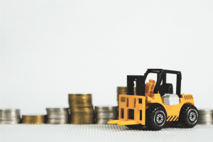 Toy forklift in front of stacks of coins