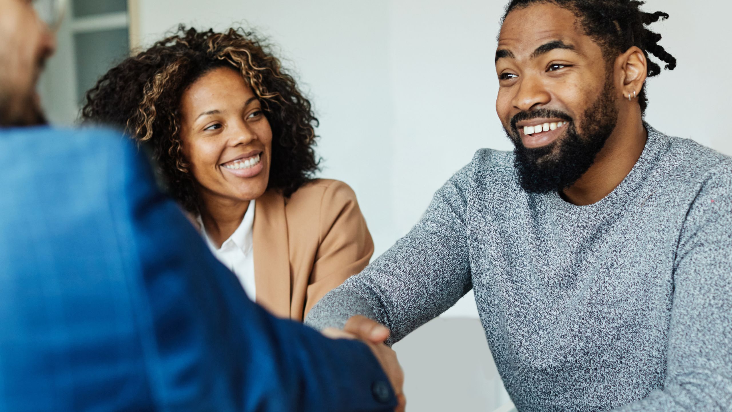 Two entrepreneurs shaking hands as they close the deal on buying their business