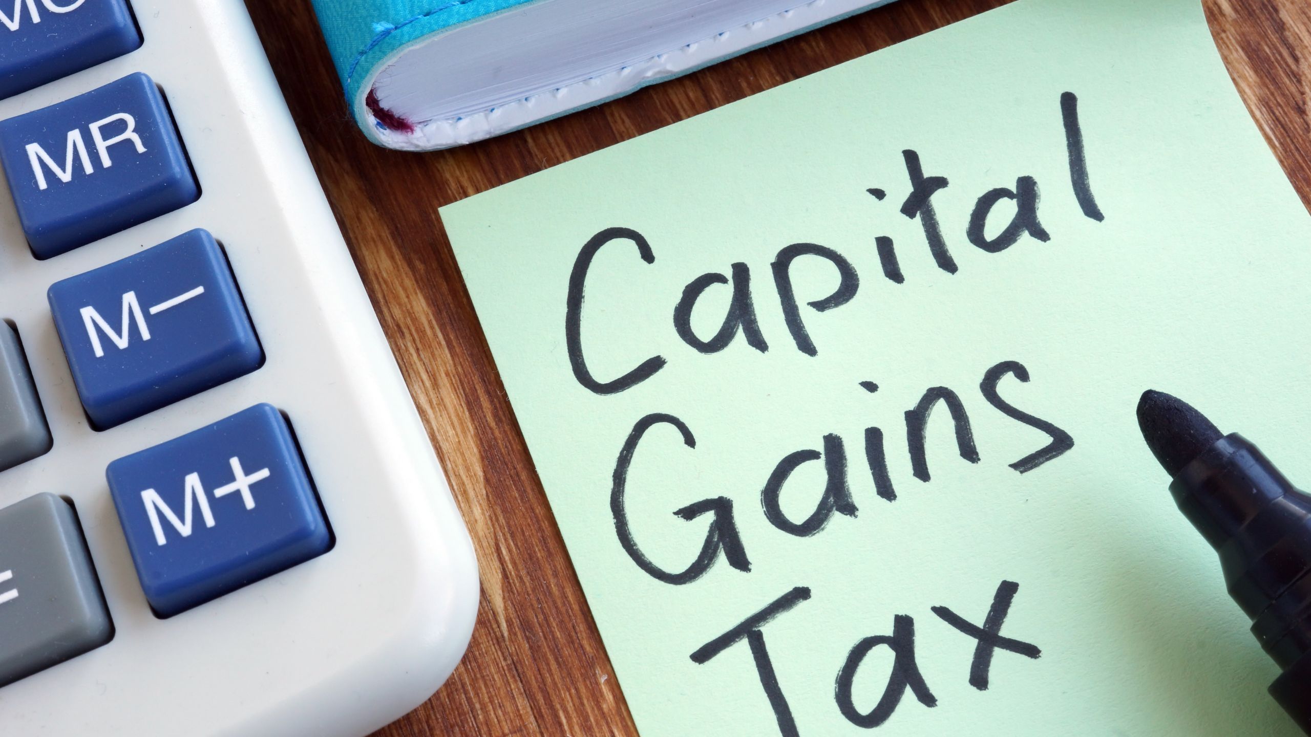 A sticky note of capital gains tax to remind a business owner to calculate theirs.
